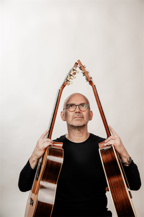 Charly SChranz hält zwei Gitarren in die Luft