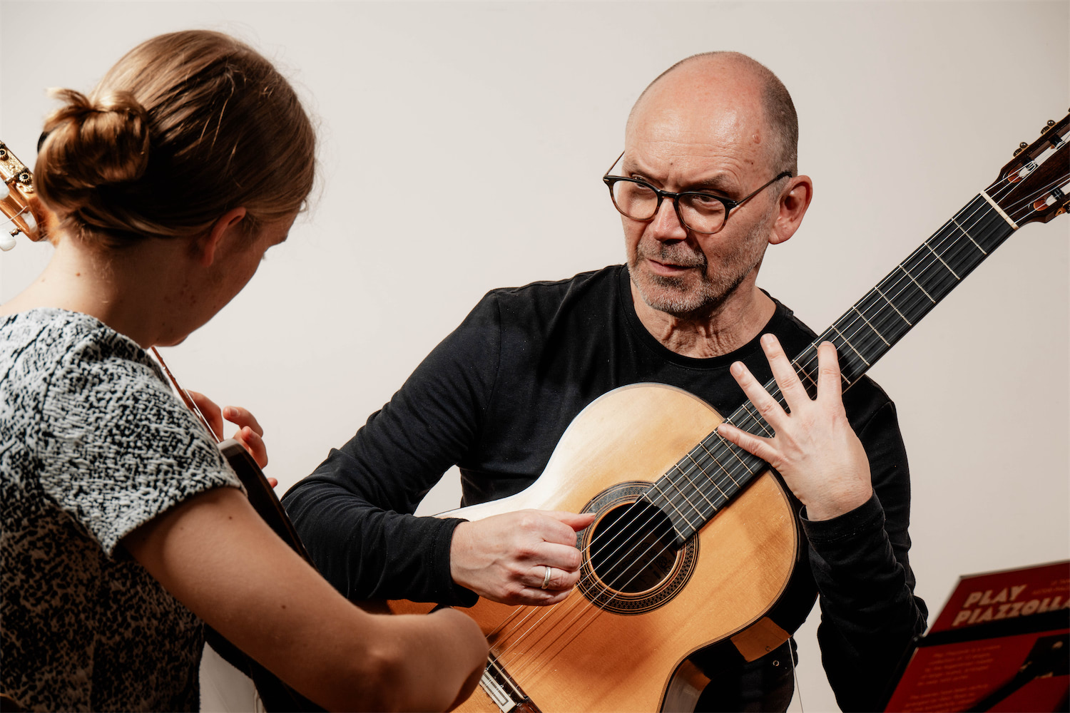 Gitarrenlehrer mit Schülerin